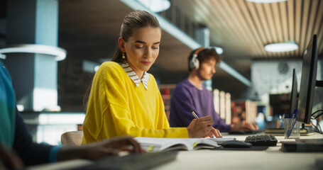 Portrait of an Enthusiastic Female Working on a Computer with a Group of University Students. Smart Young People Preparing Homework Assignments and Studying for Exams in a College Library