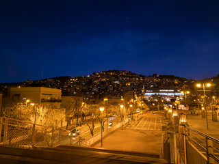 Night view of the Rambla del Carmel in the city of Barcelona with the Turó de la Rovira hill illuminated in the background