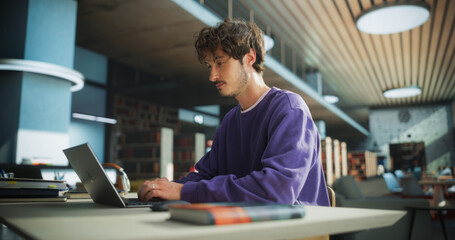 Student Studying in a Modern Library. Young Man Thinking and Problem Solving School Exercises. Male...
