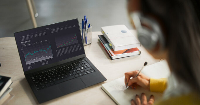 Over the Shoulder Shot with a College Student Studying Business and Finance in a Library. Anonymous Female Learning Online, Getting Ready for Management Exams