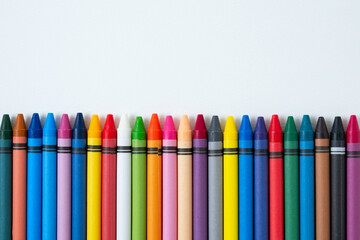 Multi-colored wax crayons for drawing on a white background