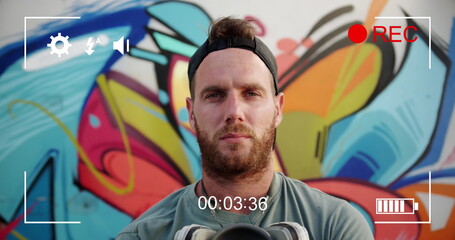 Digital camera records a young man's portrait against graffiti in 4k.