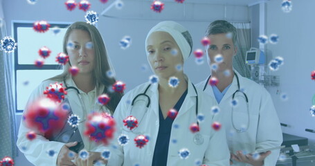 Image of a medical staff team in hospital with coronavirus cells floating on the foreground