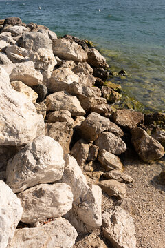 a pile of stones on the shore of the beach that are washed by the sea water 