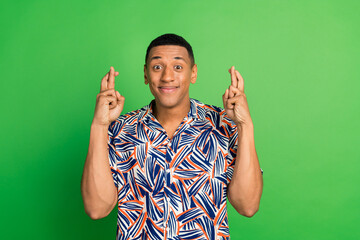 Photo of excited attractive man wearing trendy clothes standing with crossed fingers isolated on...