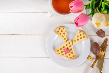 Easter breakfast or brunch. Cute creative decorated soft sweet belgian waffles shaped in form of Easter bunny rabbit, with chocolate eggs and fruits