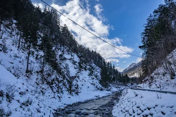 Foto op Canvas visuale panoramica su di un ambiente  naturale di montagna, all'ombra, completamente freddo e coperto di neve, nel nord Italia, sotto un cielo parzialmente sereno, di pomeriggio, in inverno © PhotoMet