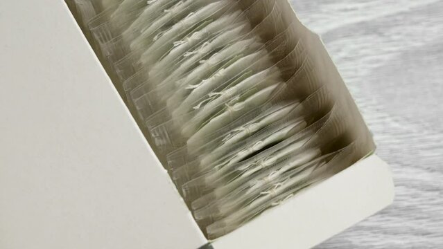 Open paper pack with herbal tea bags on a kitchen board close up. Refreshment hot drink concept. Rotation