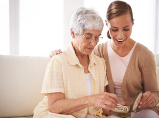 Senior woman, mother and daughter with gift for bonding, appreciation and love relaxing on sofa at...