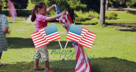 Image of usa flags over happy biracial boy and girl running with flags on grass