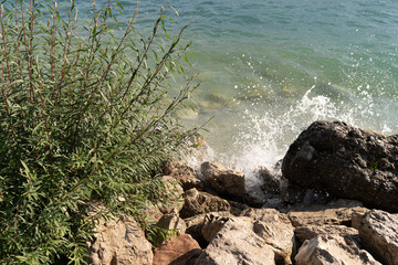 a pile of stones on the shore of the beach that are washed by the sea water