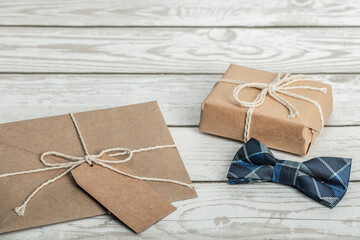 Gift boxes,envelope and bow tie on a wooden background. Concept Happy Birthday, Father's Day.