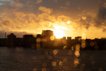 View of the river Thames and South London on a stormy sunset. Raindrops have created dramatic bokeh against the storm clouds and silhouetted buildings. 