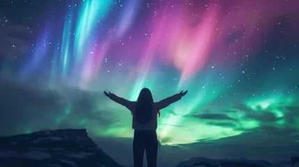 Cercles muraux Aurores boréales A person stands in snow field wow with beautiful aurora northern lights in night sky in winter.