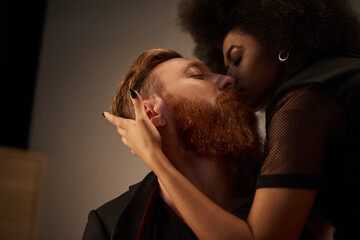 Romantic night of diverse couple in intimate setting, african american woman kissing tattooed man