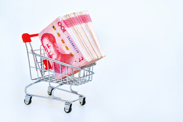 Shopping cart with 100 Yuan Chinese money inside on white background. Concept of money and economy of the consumer.