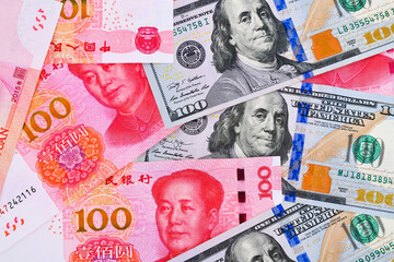 100US dollar and 100 Chinese yuan renminbi banknotes background.	