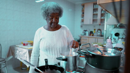 Elderly Senior African American woman preparing meal at home in casual domestic lifestyle scene in...