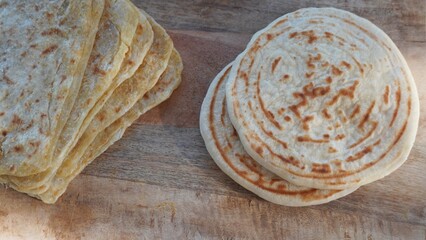 Freshly baked Moroccan flaky pancakes on a wooden table. 
