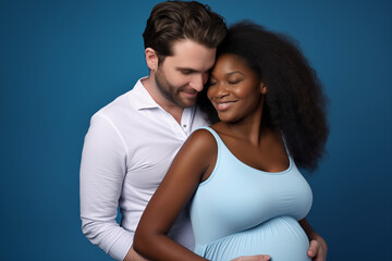A cheerful interracial couple expecting a baby share a warm embrace, displaying affection and anticipation for their future child.

