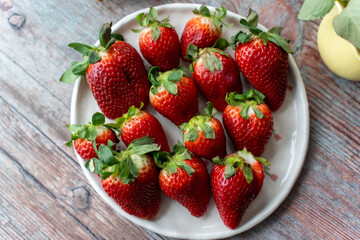 Ripe strawberries in a plate on the table. 