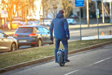 Man navigate urban landscape on monowheel unicycle, an innovative and eco-friendly electric mobility solution for solo riders. Urban transportation with modern self-balancing vehicle.