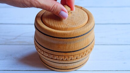 Salt gracefully pours into wooden jar creating serene scene. Witness rhythmic flow as salt fills container, an enchanting sight. Perfect for culinary content creators showcasing beauty of salt storage