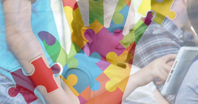 Image of puzzle pieces and hand over diverse schoolchildren using tablet - Powered by Adobe
