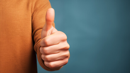 A hand giving the thumbs-up gesture, signifying success, approval, or positivity