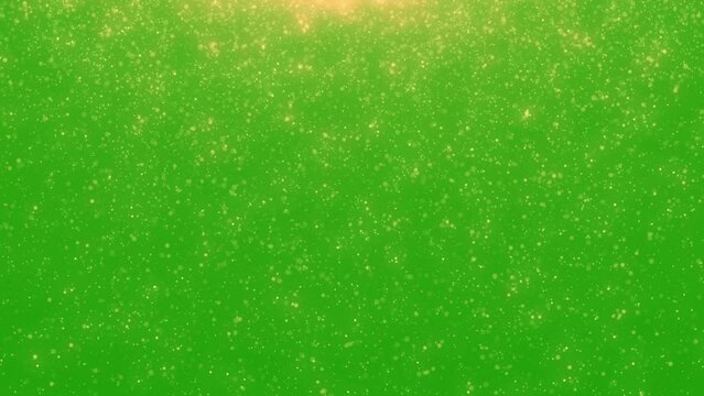Golden glitter rain, gold particles glow with falling snow bokeh light effect on green background. Motion graphic