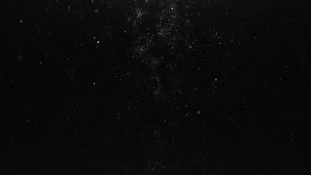 White particle scatter glitter confetti on dark background. Motion graphic
