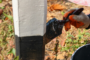 The black-and-white navigation roadside pillars are being repainted to make them more visible. Rural road officials are rushing to paint road pillars during the summer in rural Thailand.