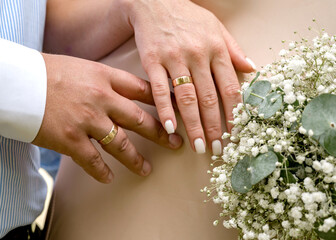 Obraz na płótnie Canvas Hands of newlyweds with wedding rings