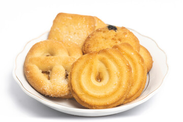 Group of assorted of danish butter cookies in a small white plate isolated on white background clipping path