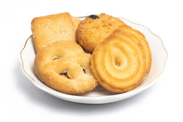 Group of assorted of danish butter cookies in a small white plate isolated on white background clipping path