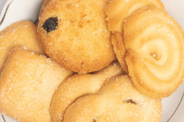 Close-up group of assorted of danish butter cookies in a small white plate top view isolated on white background clipping path