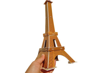 a person holds in his hand the Eiffel Tower made of 3d puzzle