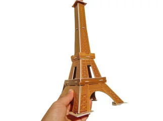 Photo sur Aluminium Tour Eiffel a person holds in his hand the Eiffel Tower made of 3d puzzle