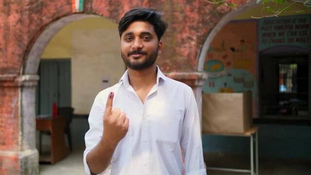 Responsible citizen showing the ink mark on his index finger after casting his vote - assembly election  general election. Mature adult male encouraging others to vote outside the polling booth - e...