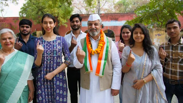 Supports of a political party showing ink sign on their index finger after casting their vote - assembly elections. Political leader along with his party members asking for vote during elections - ...