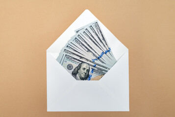 Paper envelope with dollar bills on a brown background, top view - 758001569