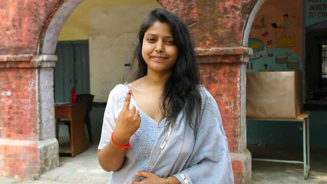 Female Indian voter showing the ink sign on her index finger after casting her vote - assembly election  state election. Responsible adult female encouraging people to vote during the elections - c...