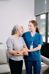 Obraz premium Young Caregiver doctor examine older patient use blood pressure gauge. woman therapist nurse at nursing home taking care of senior elderly woman sit on sofa.