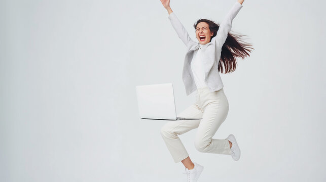 This full-length image depicts the sheer joy of a female freelancer who has just received news of securing a new job,her beaming smile and laptop in hand painting a picture of achievement and happy