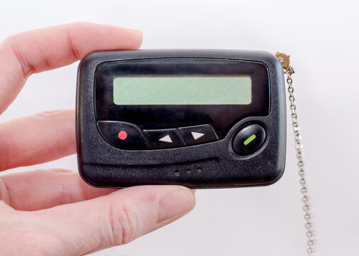 pager in close-up, an old retro communication device, in female hand on a white background