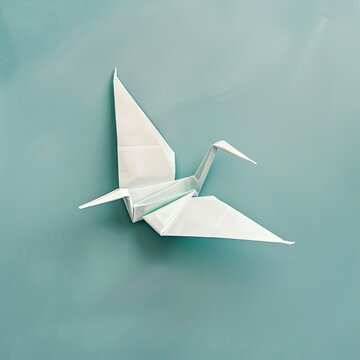 A simple white origami crane positioned against a soft