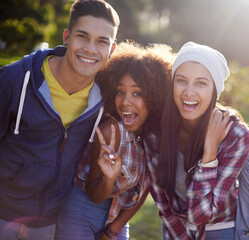 Portrait, smile and diversity student friends in nature, outdoors or garden with happy expression. Hug, joy and peace sign hand gesture from female person, university and excited learner in school