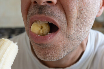 Detail of a Man's Mouth Biting a Banana