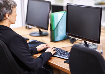 Business woman, computer and typing in an office with email, blank monitor and internet at company. Desktop, professional and female person with technology of website manager at a desk with worker