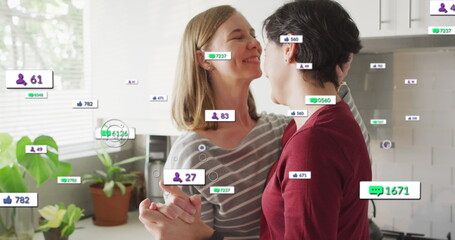 Image of social media icons and numbers over lesbian caucasian couple at home